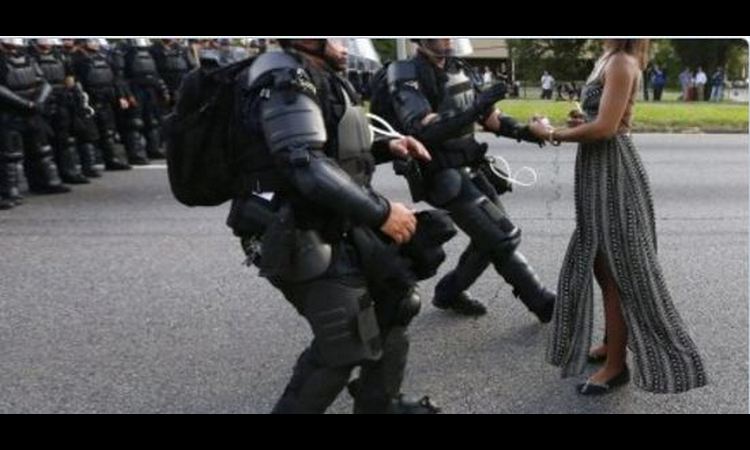 FOTOGRAFIJA KOJA JE OBIŠLA SVET: Ona je MIRNO stajala dok su je  hapsili pod PUNOM OPREMOM (FOTO)